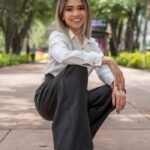 Fashionable Latina woman smiling confidently outdoors in Ciudad de México park.
